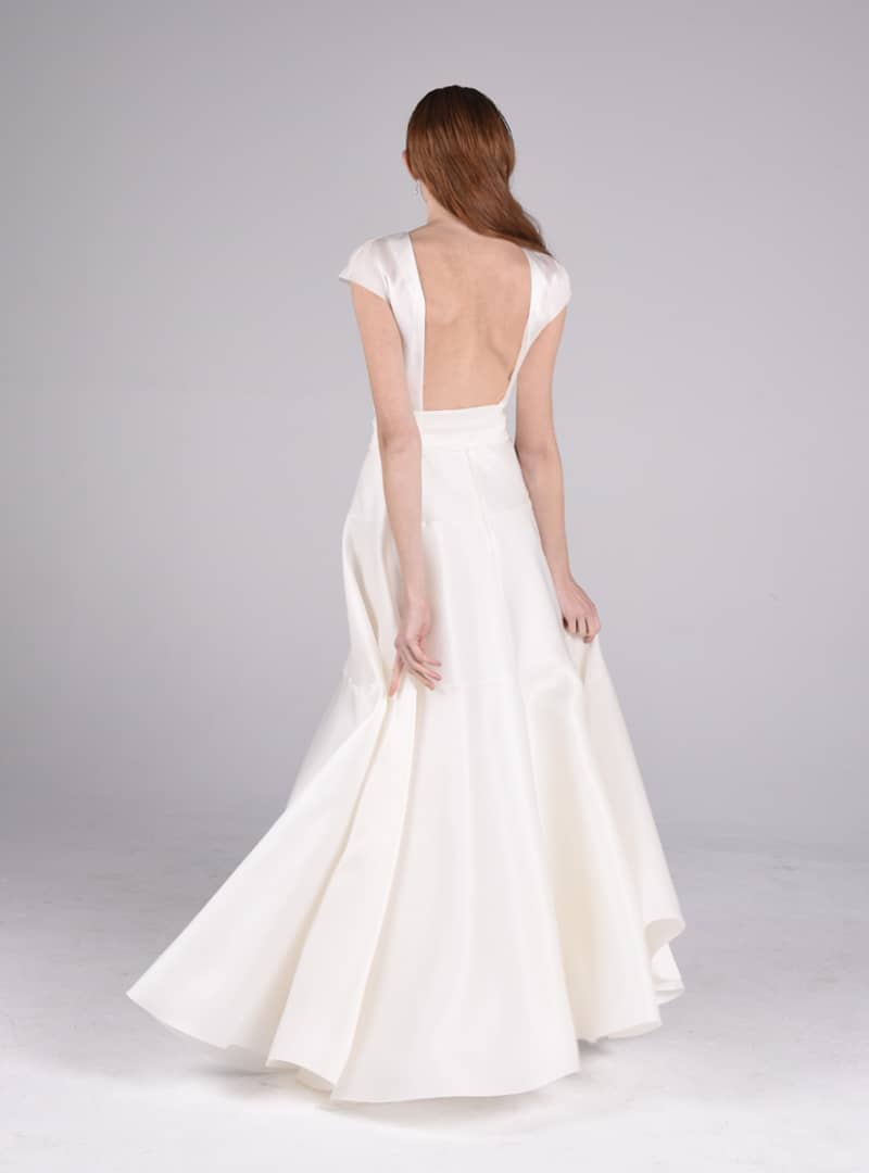 Olivia és un afavoridor disseny per vestit de núvia de CRISTINA SAURA. Construït amb triple organdí de seda, el tall defineix la línia de la cintura fins al maluc i augmenta el seu volum generosament en el baix.